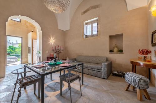 - un salon avec une table, des chaises et un canapé dans l'établissement La Salentina Otranto - Happy Rentals, à Carpignano Salentino