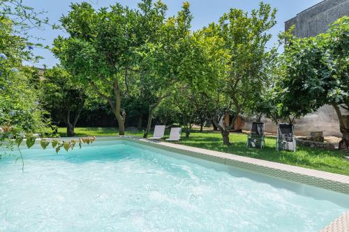 uma piscina num quintal com árvores em La Salentina Otranto - Happy Rentals em Carpignano Salentino