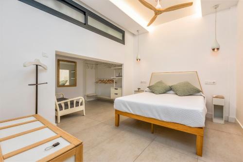 a white bedroom with a bed and a table at Casa Lola Fuengirola centro in Fuengirola