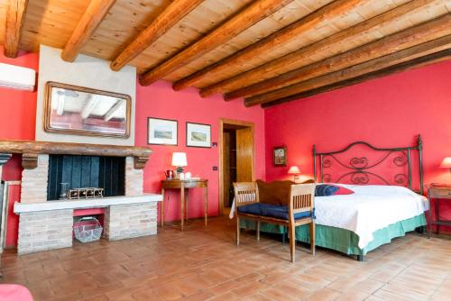 een slaapkamer met rode muren, een bed en een open haard bij Musella Winery & Relais in San Martino Buon Albergo