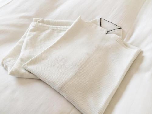 a pair of white pants laying on a bed at Bright Park Hotel - Vacation STAY 67876v in Kochi