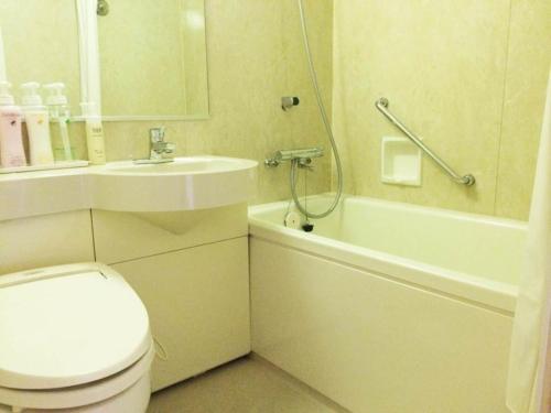 een badkamer met een toilet, een wastafel en een bad bij Bright Park Hotel - Vacation STAY 67876v in Kochi