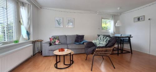 a living room with a couch and a table at Chalet Esdoorn in Putten, Gezellig en Luxe gerenoveerd in Putten