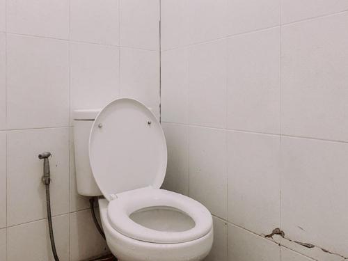 - une salle de bains avec des toilettes blanches dans une cabine dans l'établissement Penginapan Steady Mitra RedDoorz, à Pematang Siantar