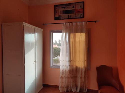 a room with a window and a curtain at Keur Magatte in Saint-Louis