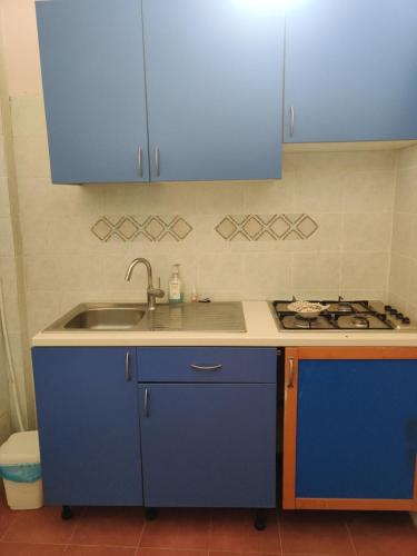 a kitchen with blue cabinets and a sink at Keur Magatte in Saint-Louis