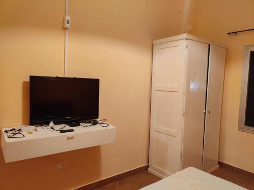 聖路易斯的住宿－Keur Magatte，一间带电视和白色橱柜的卧室