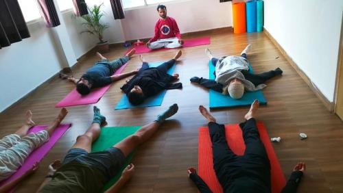 a group of people laying on the floor doing yoga at Rudram Hotel Yoga & Ayurveda Retreat in Rishīkesh