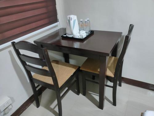 Una mesa negra con dos sillas y una cafetera. en DULLI TRANSIENT HOUSE en Lipa