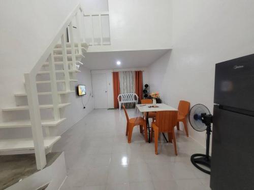 eine Küche und ein Esszimmer mit einem Tisch und Stühlen in der Unterkunft Budget friendly yet cozy staycation in Calapan