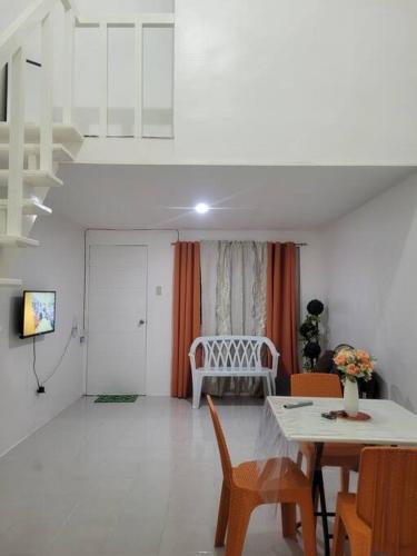 a living room with a table and chairs and a couch at Budget friendly yet cozy staycation in Calapan