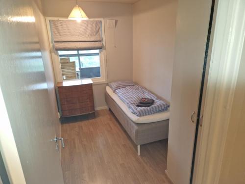 Cette petite chambre comprend un lit et une fenêtre. dans l'établissement Toppleilighet i Fana, à Bergen