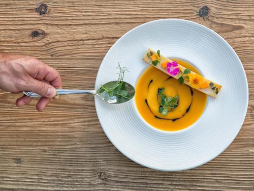 a person eating a bowl of soup with a spoon at Astor Hotel in Schenna
