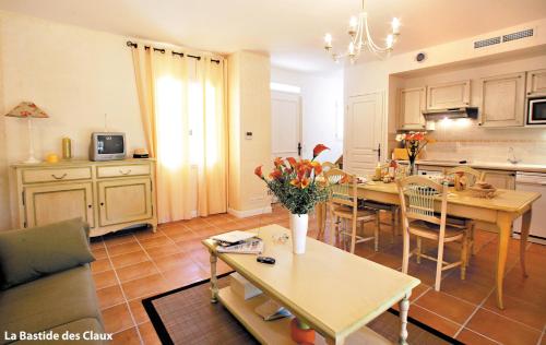 a kitchen and living room with a table and chairs at Lagrange Vacances Domaine de Fayence in Fayence