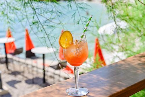 a drink sitting on a wooden table with an orange slice at Mobile Homes Krk Silo in Šilo