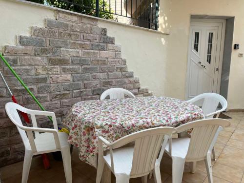 stół i cztery krzesła ze stołem i ceglaną ścianą w obiekcie Family Garden w mieście Néa Michanióna