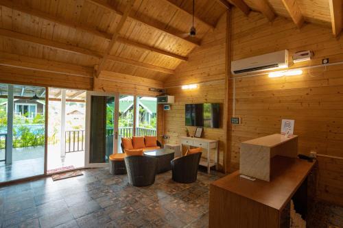 a living room with wooden walls and a wooden ceiling at Kanasu The Resort - Cottages & Farm House in Udupi