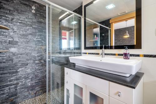a bathroom with a white sink and a glass shower at Villa Sabela in Segur de Calafell