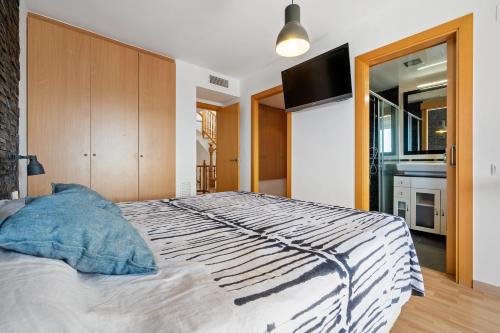 1 dormitorio con 1 cama grande y TV. en Villa Sabela, en Segur de Calafell