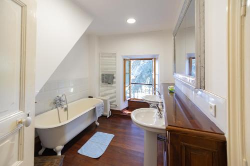 a bathroom with a tub and a sink and a bath tub at Le Grand Cèdre - Maison avec piscine privée in Ribes