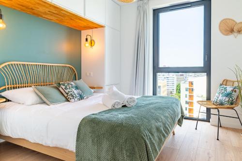 a bedroom with a bed and a large window at Loire Enchantée - Appt sur lîle de Nantes in Nantes