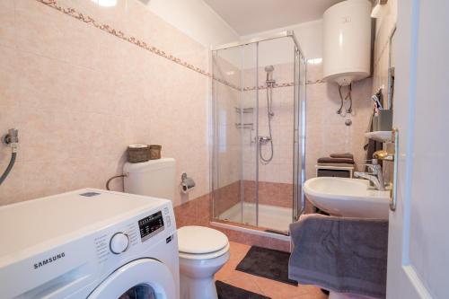 La salle de bains est pourvue d'un lave-linge et d'un lavabo. dans l'établissement Charmante Wohnung fußläufig zum Meer in Funtana, à Funtana