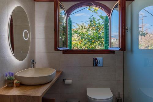a bathroom with a sink and two windows at Amor Villa in Laganas