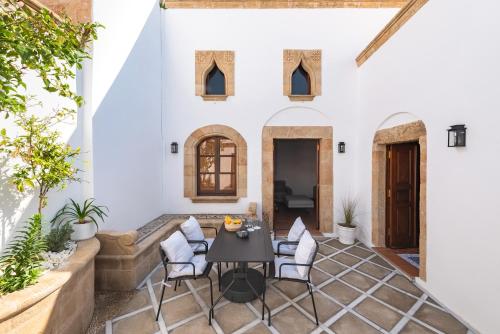 a patio with a table and chairs in front of a building at Althea Villa in Lindos