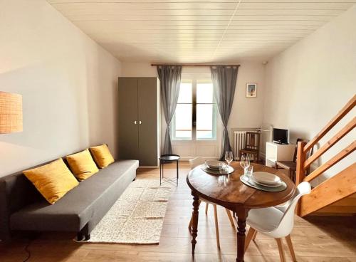 sala de estar con sofá y mesa en * Le Grand Hotel * Beau T1 Bis avec vue, en Font-Romeu-Odeillo-Via