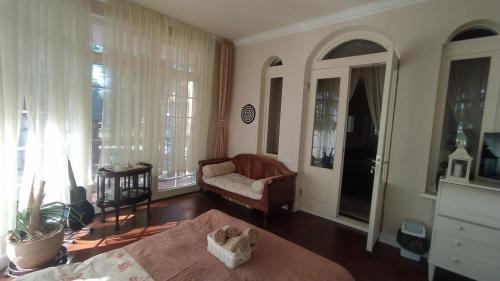 a bedroom with a bed and a couch and a window at Jumpravas pils in Jumprava
