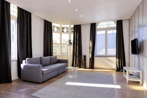 a living room with a couch and some windows at Smartflats - Meir Antwerp in Antwerp