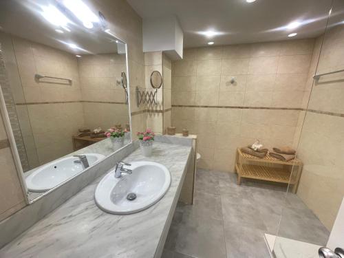 a bathroom with a sink and a tub and a mirror at RealRent Costa Teguise Beach in Costa Teguise
