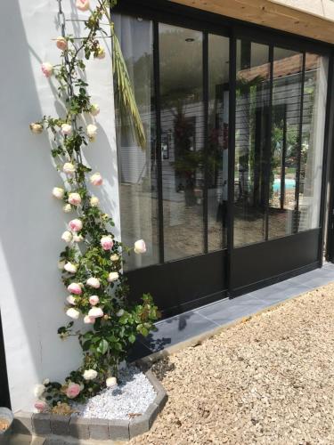 a plant with pink roses on the side of a building at Chambre Cosy Chic in Challans