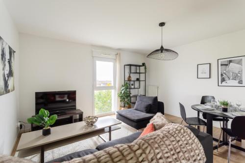 un salon avec un canapé et une table dans l'établissement Le Mint - Appt 2 chambres avec parking, à Rennes