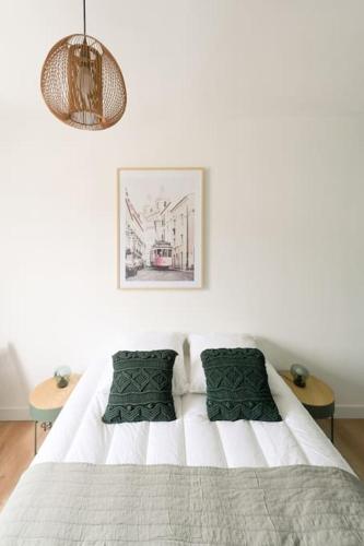 - une chambre blanche avec un lit blanc et des oreillers verts dans l'établissement Soif d'Evasion - 4 personnes, au Havre