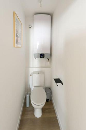 une petite salle de bains avec des toilettes blanches dans le couloir dans l'établissement Soif d'Evasion - 4 personnes, au Havre