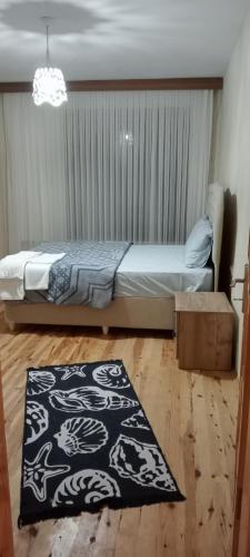Schlafzimmer mit einem Bett und einem schwarzen und weißen Teppich in der Unterkunft Alkurtoğlu Pansiyon&cafe& restoran in Macka