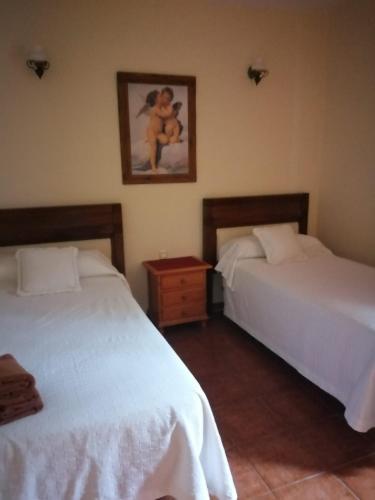 1 dormitorio con 2 camas y una foto en la pared en Casa José, en Tajace de Abajo