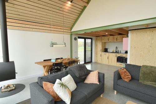 a living room with a couch and a table at Vakantiehuisje Buuf in de Brabantse natuur in Schijndel