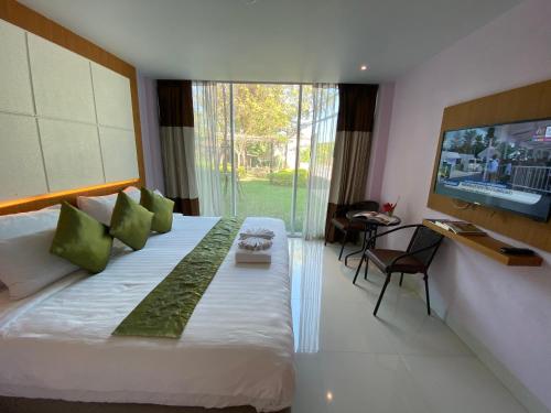 - une chambre avec un grand lit et une télévision à écran plat dans l'établissement A Hotel Simply, à Chiang Saen