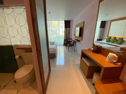 - une salle de bains avec toilettes et un lit dans une chambre dans l'établissement A Hotel Simply, à Chiang Saen