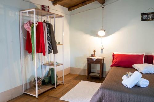a bedroom with a bed and a rack of clothes at Casa storica Austis, Sardegna in Austis