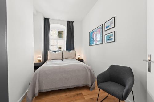 a bedroom with a bed and a chair at The Straßburger, stylish 3 BR apartment in Mitte, group & family friendly, 4- 6 Guests in Berlin