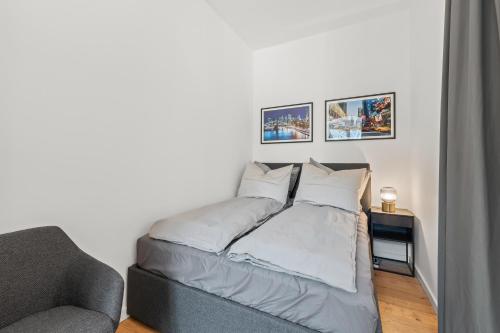 a bed in a room with a couch and pictures on the wall at The Straßburger, stylish 3 BR apartment in Mitte, group & family friendly, 4- 6 Guests in Berlin