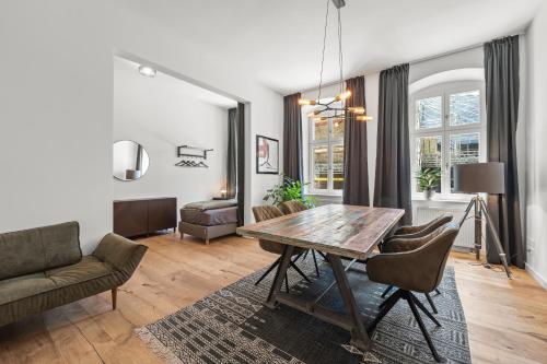 a living room with a wooden table and chairs at The Straßburger, stylish 3 BR apartment in Mitte, group & family friendly, 4- 6 Guests in Berlin