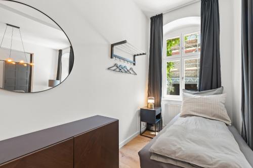 a bedroom with a mirror and a bed at The Straßburger, stylish 3 BR apartment in Mitte, group & family friendly, 4- 6 Guests in Berlin