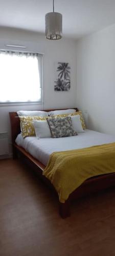 une chambre avec un grand lit avec une fenêtre dans l'établissement Bel appartement près de Vannes - Golfe du Morbihan, à Séné