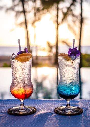 two cocktails sitting on top of a table at The Haven Khao Lak in Khao Lak