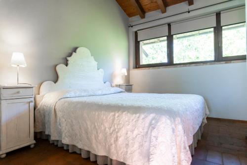 a bedroom with a white bed and a window at Musella Winery & Relais in San Martino Buon Albergo
