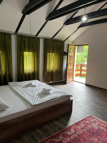 a large bed in a room with a large window at Azra River View House in Bihać